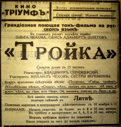 Реклама кинотеатра «Триумф». Завтра исключительная премьера! Сенсация сезона! Мировой шедевр! Грандиозная поющая тон-фильма на русском языке. В главных ролях корифеи экрана: Ольга Чехова, Ганс Адальберт Шлетов. «Тройка» Сильная драма в 15 частях. Режиссер: Владимир Стрижевский. Участвуют: Михаил Чехов, Сестры Веревкины. Все зимние снимки этого шедевра сделаны в Литве.
