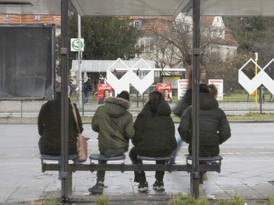 PRODUCTION - 08 January 2023, Berlin: Four people wait for a bus on Sonnenallee not far from the high-deck housing estate in Neukölln. There, as in numerous other places in the city, violence escalated on New Year's Eve. Unknown persons set fire to a bus in the underpass. Politicians, police and various associations are now looking for solutions. Photo: Paul Zinken/dpa