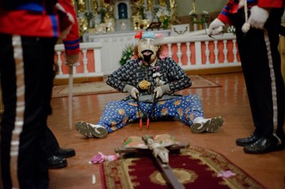 "Velykžydžiai" bažnyčioje kelia sąmyšį ir visą vakarą nepertraukiamai taikosi į kryžių. „Manau, ši šventė yra graži kaimo tradicija“, - pasakoja Jonas, kauke prisidengęs vaikinas.