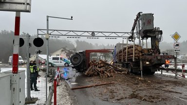 Около железнодорожного переезда в Юодшиляй перевернулся прицеп лесовоза