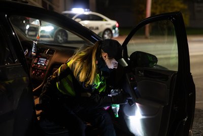 Pareigūnė tikrina automobilį