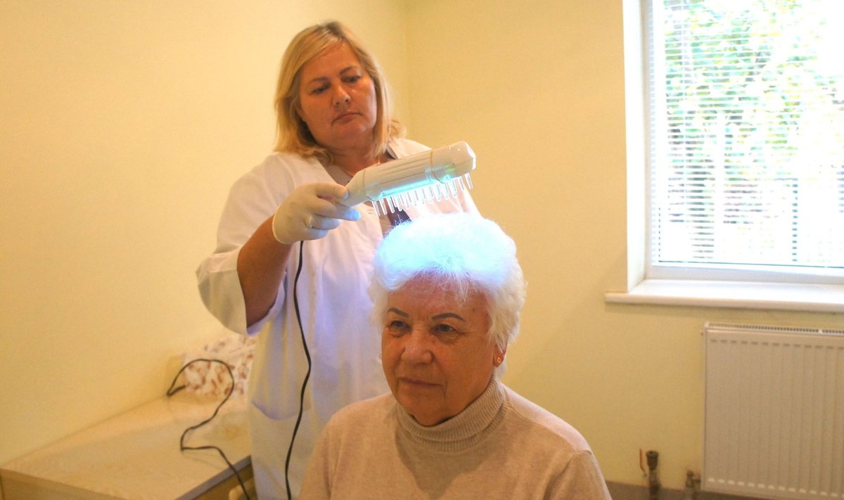 Respublikinės Šiaulių ligoninės Onkologijos klinikos Odos ir veneros ligų skyriaus bendrosios praktikos slaugytojos Rasos Lukoševičienės atliekama fototerapija UV šukomis padeda įveikti galvos žvynelinę.