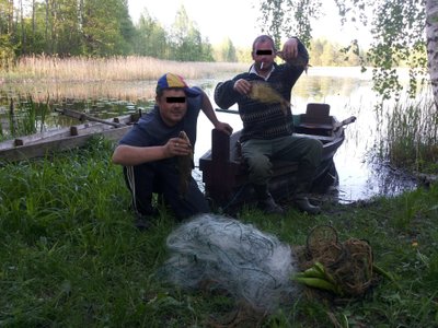 Brakonieriai šalia valties, kuri iš jų bus konfiskuota  