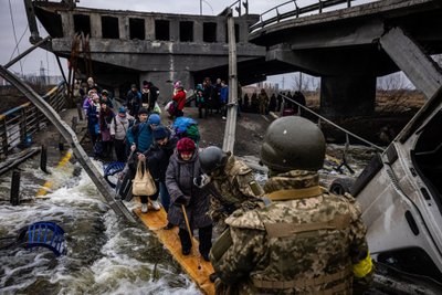 Ukrainos kariai padeda ištrūkti žmonėms iš po sugriauto Irpinės tilto, kuris buvo civilių gyventojų pabėgimo kelias iš miesto. 2022, kovo 7 d., Ukraina