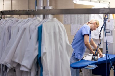 Kauno klinikų skalbykla: medikų uniformų lyginimas