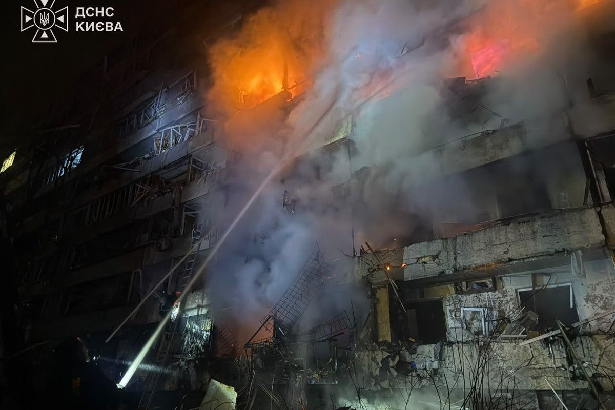 A building on fire with smoke and emergency lights
